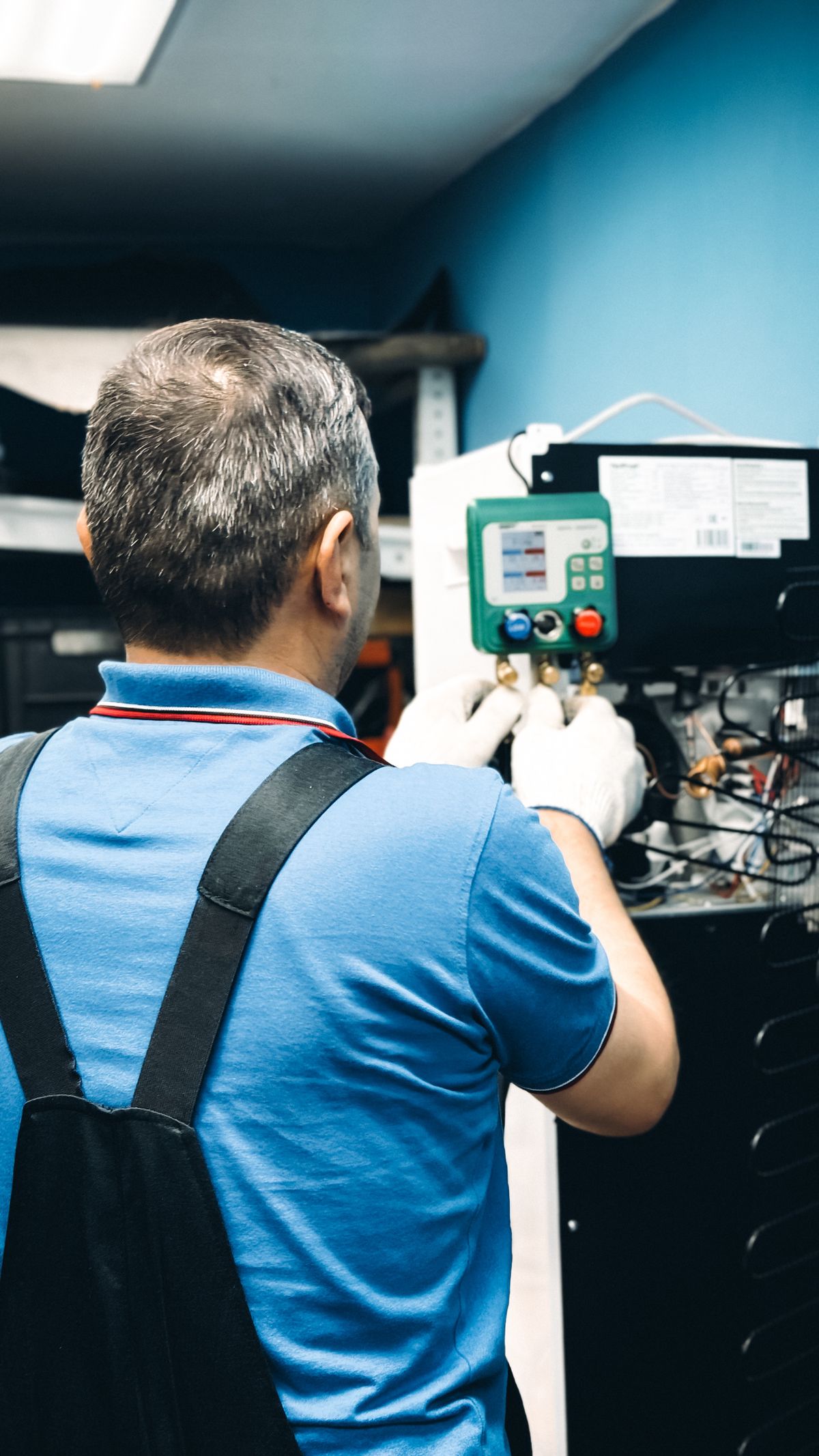 Técnico medindo pressão do sistema com manifold digital