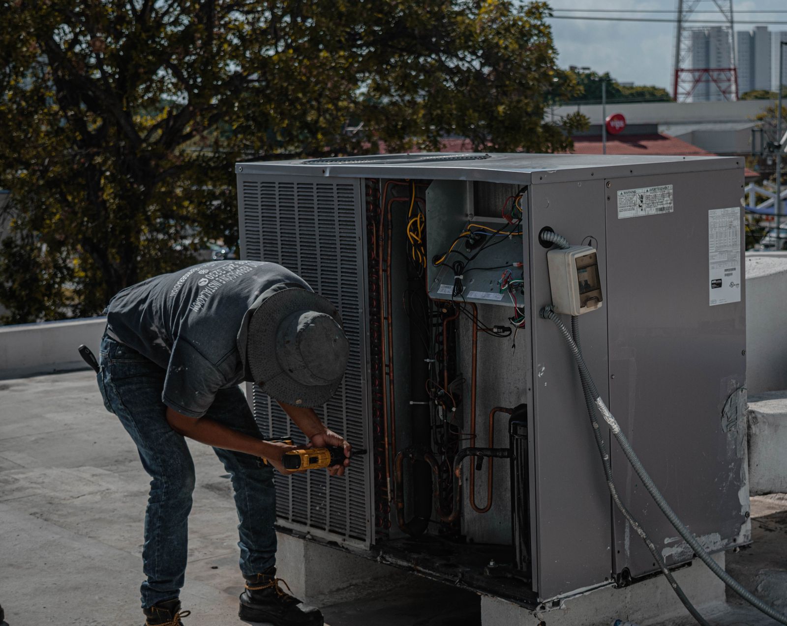 Técnico em manutenção de condensadora no telhado